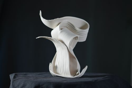 Ceramic white sculpture, abstract, on a black background