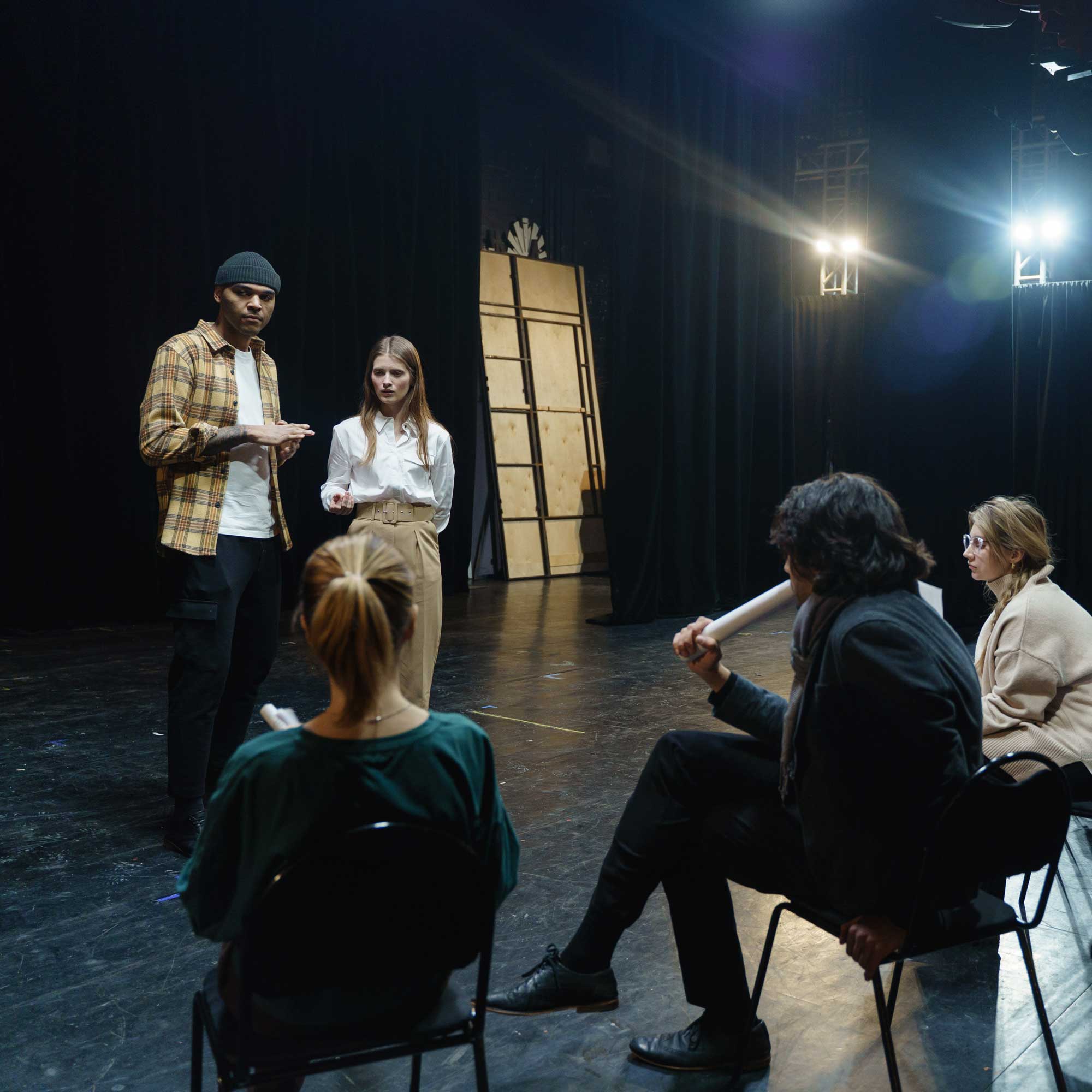 A group of performers meet in a theatre stage