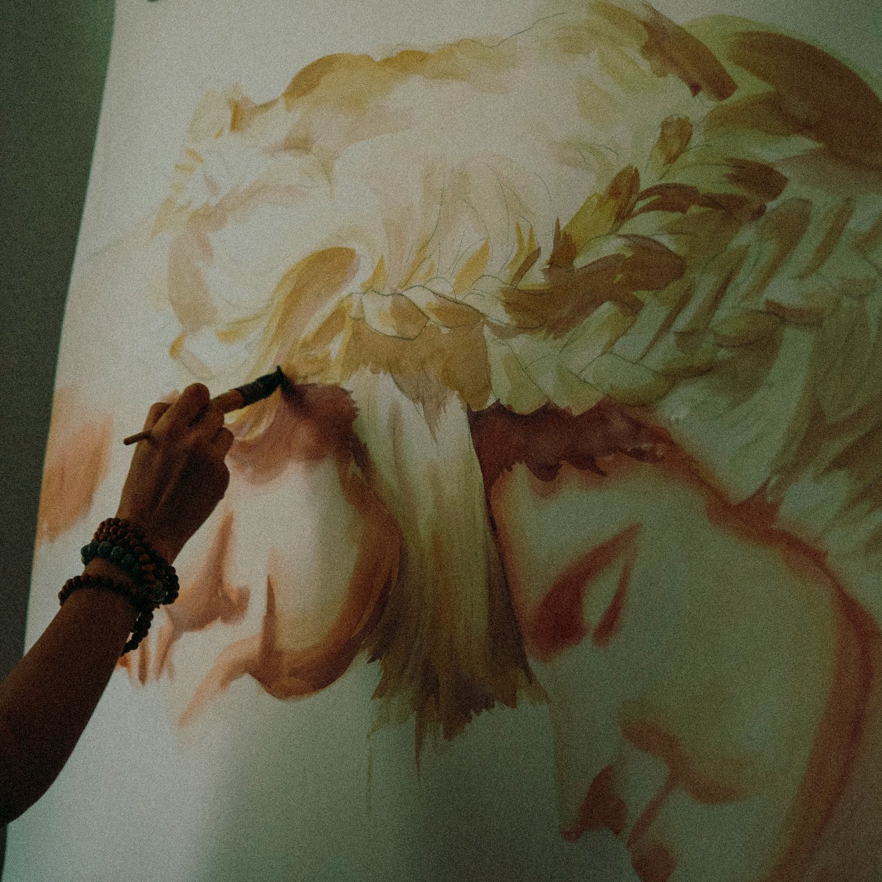 Hand painting an image with two heads.